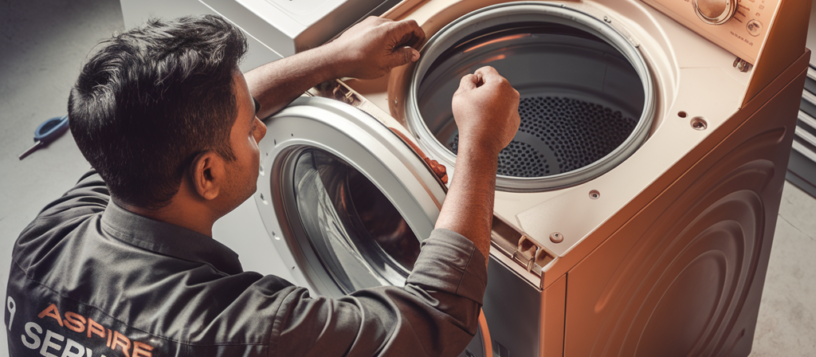 Aspire Services technician in a black uniform expertly repairing a top-load washing machine, demonstrating professionalism and skill in appliance maintenance. Washing machine Repair Service in Mysore