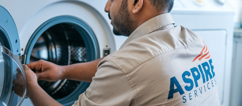 Aspire Services Technician wearing Cream color Uniform Repairing a white front load washing Machine in Mysore